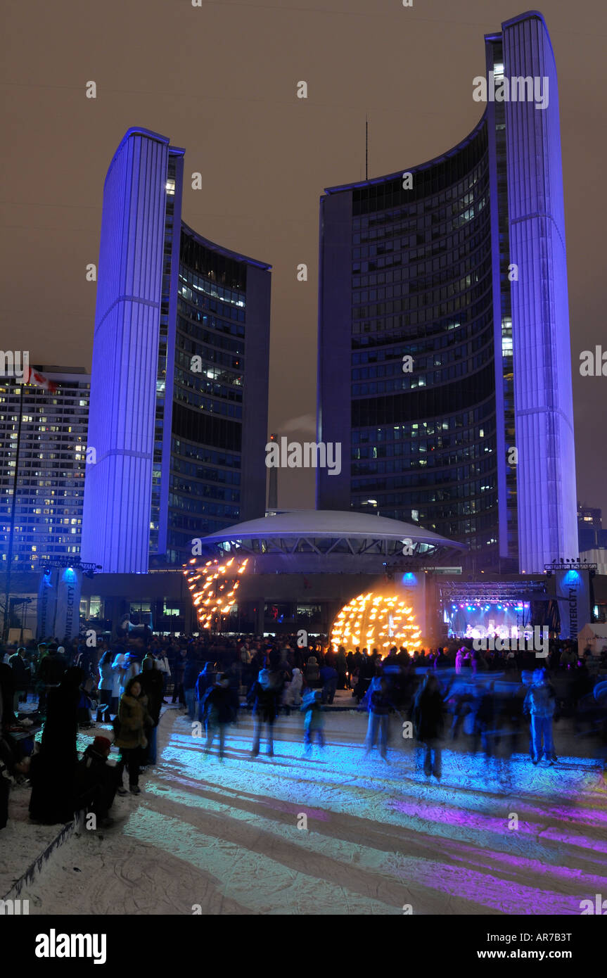 I pattinatori sulla pista di pattinaggio su ghiaccio a Toronto City Hall durante Wintercity notti di fuoco e Weakerthans musicisti rock stage mostra le prestazioni Foto Stock
