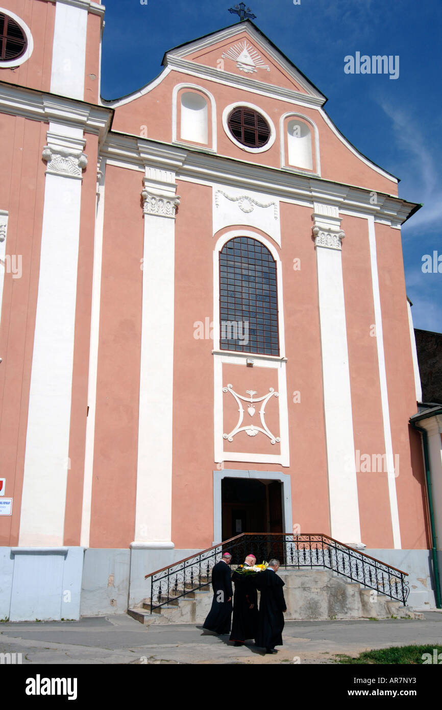 Tre uomini del panno passato a piedi in una chiesa di Roznava in Slovacchia orientale. Foto Stock