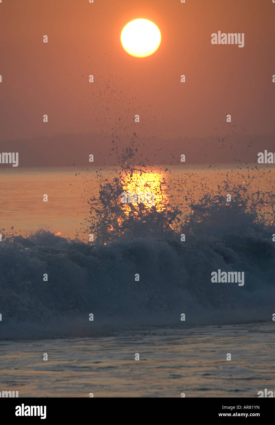 Il tramonto e la rottura di onda Foto Stock