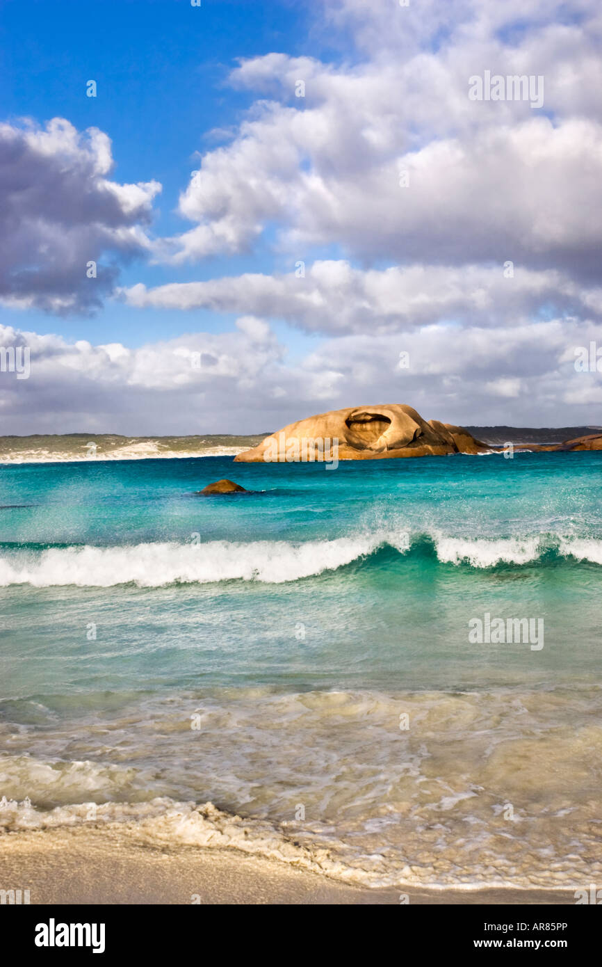 Un onda che si infrangono sulla spiaggia al crepuscolo con un affioramento di granito il ricovero di costa. Esperance, Australia occidentale Foto Stock
