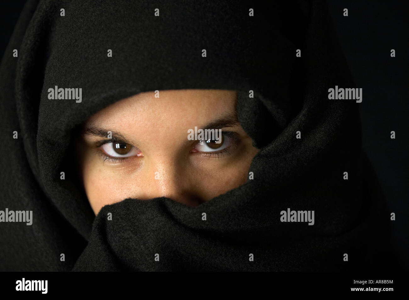 Un simpatico giovane donna caucasica con gli occhi che mostra la testa coperta con un panno nero Foto Stock