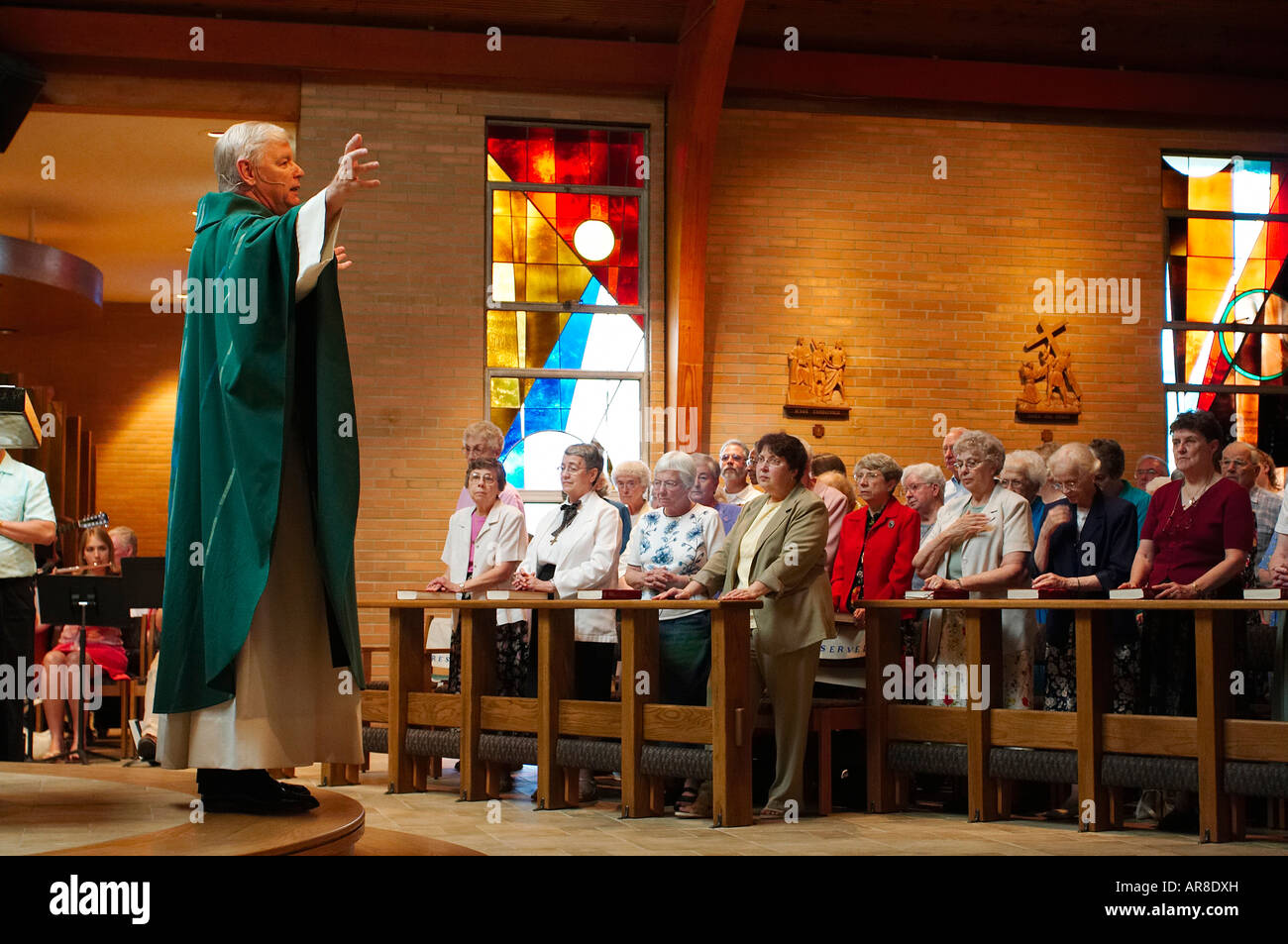 Un prete cattolico offrendo un omelia di una congregazione Foto Stock