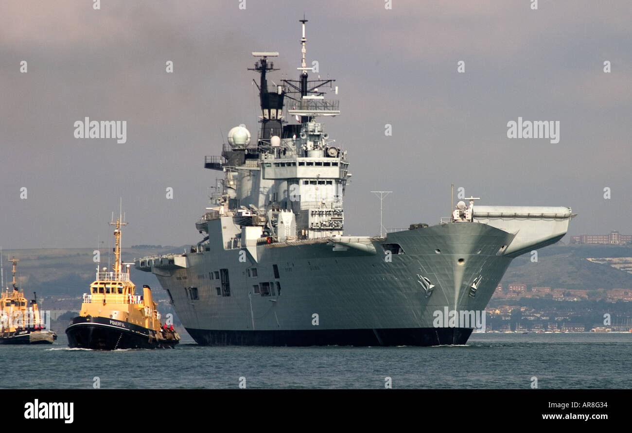 HMS illustre, Royal Navy portaerei di lasciare il suo posto di ormeggio a RNA il porto di Portsmouth Foto Stock