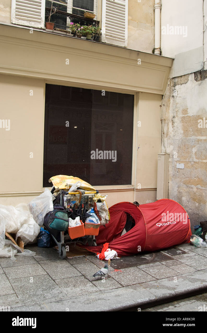 La persona senza dimora che vivono in una tenda tra tutti i loro averi in una strada a Parigi Foto Stock