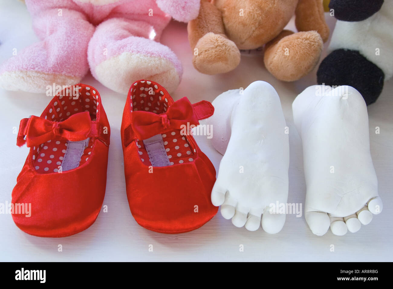 Nuova data di nascita del bambino in piedi orientabili e piccole scarpe rosso Foto Stock