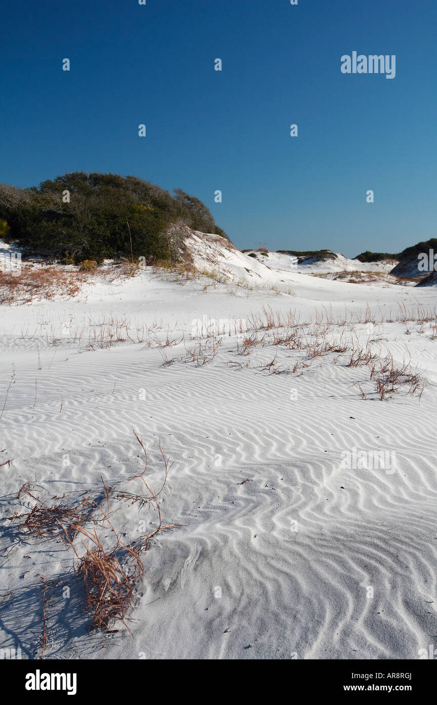Le dune di sabbia bianca con erba colline coperte contro un cielo blu Foto Stock