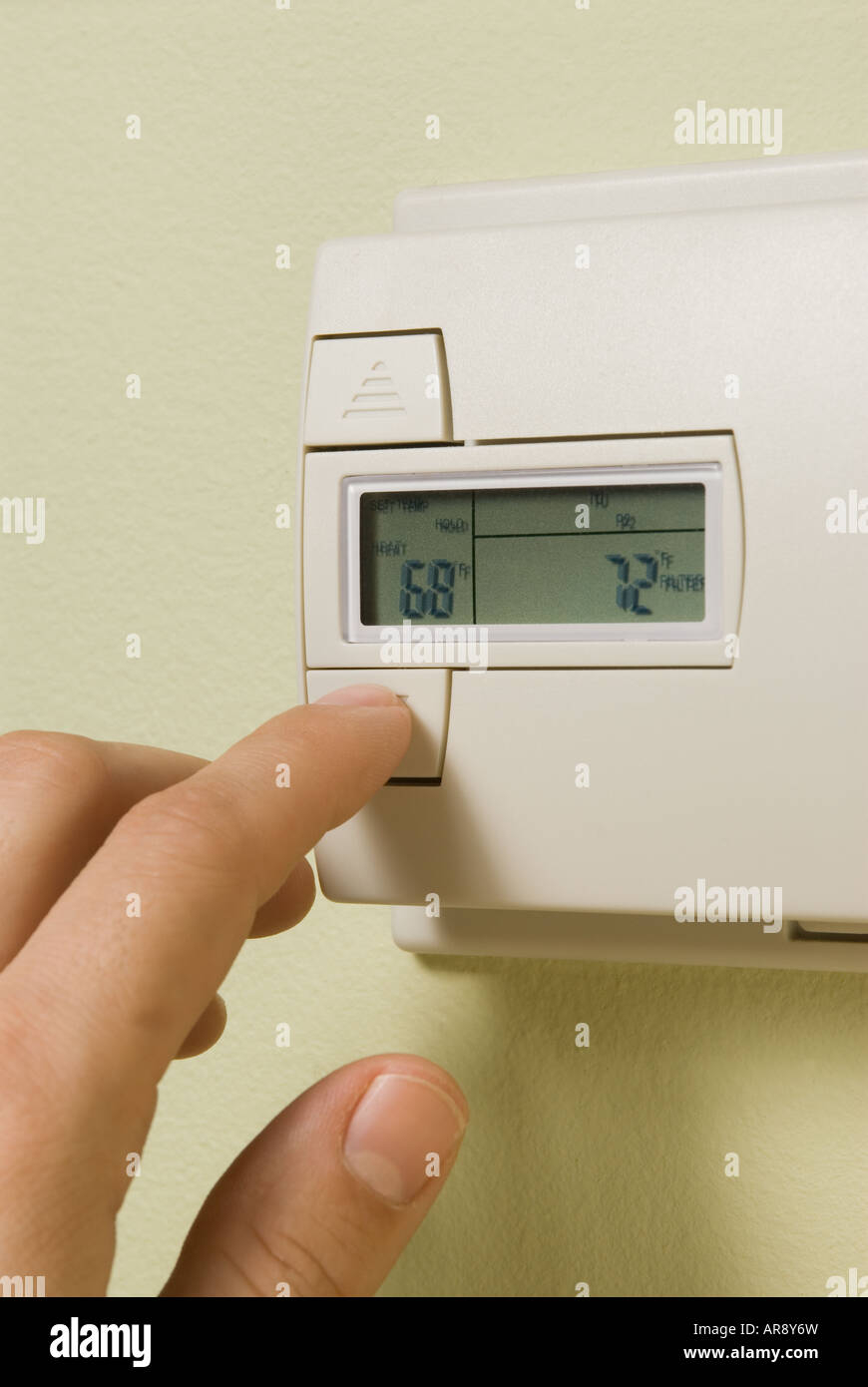 La regolazione di un termostato di casa per risparmiare energia Foto Stock