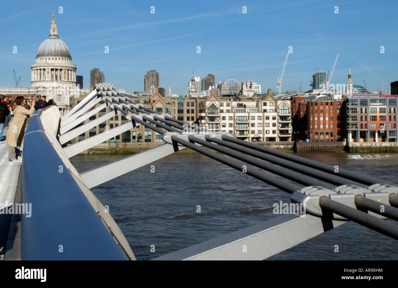 Londra Inghilterra il Millennium Bridge e waterside proprietà lungo il fiume Tamigi Foto Stock