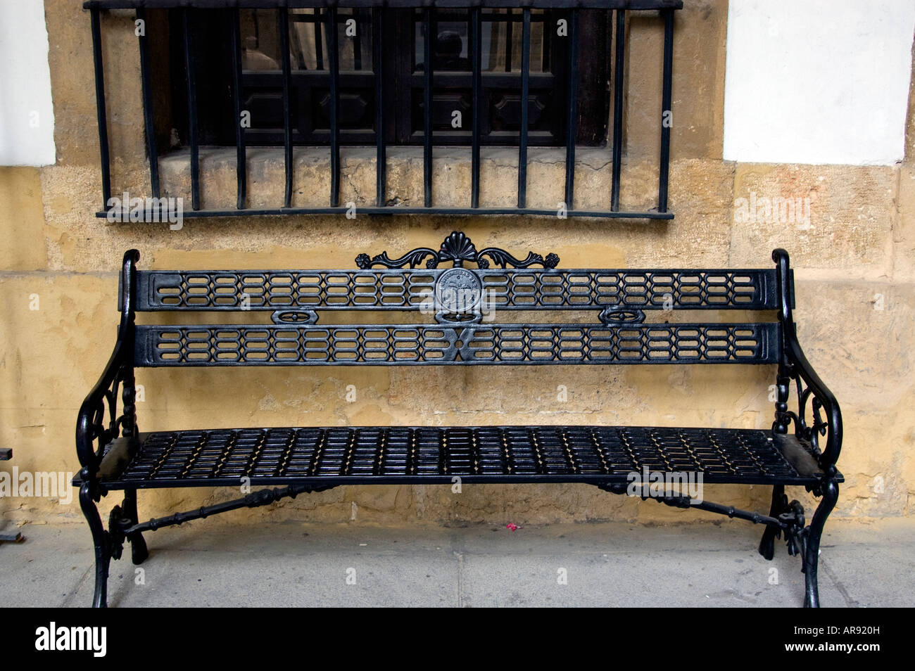 Vecchio ornati in ferro banco nero presso il patio dell Università di Siviglia, in Andalusia; Spagna Foto Stock