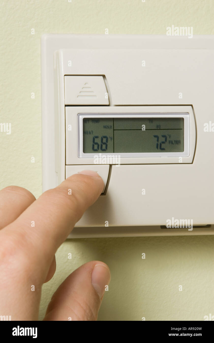 La regolazione di un termostato di casa per risparmiare energia Foto Stock