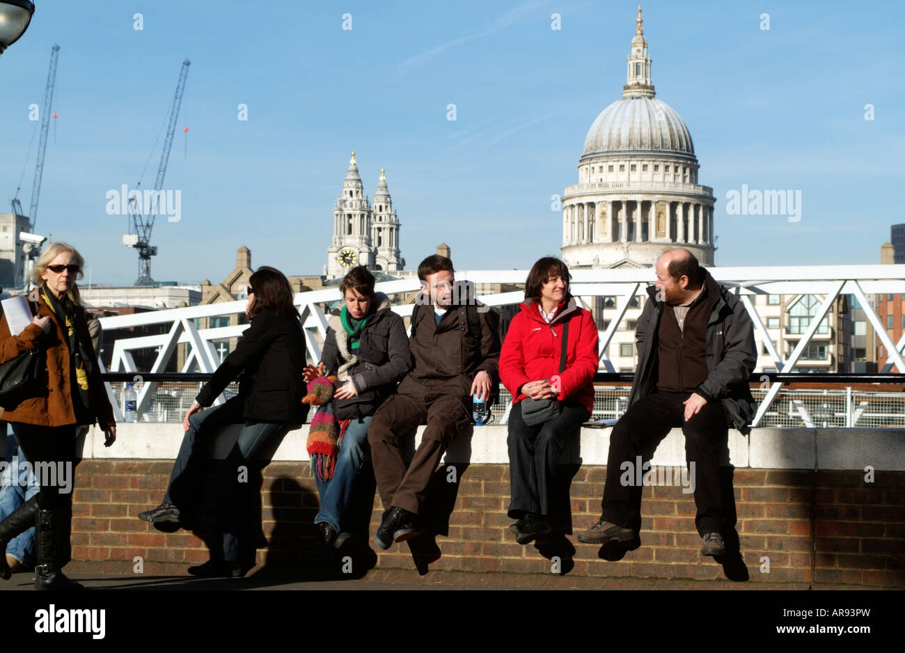 I turisti seduti su un muro sullo sfondo di St Pauls Cathedral Londra Inghilterra REGNO UNITO Foto Stock
