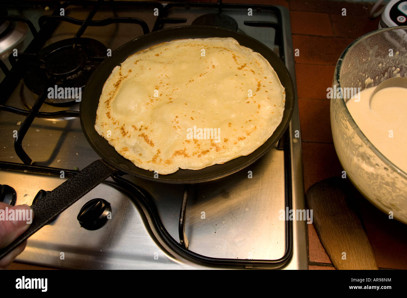 La cottura di una casa fatta crêpe in una padella il martedì grasso ,REGNO UNITO Foto Stock