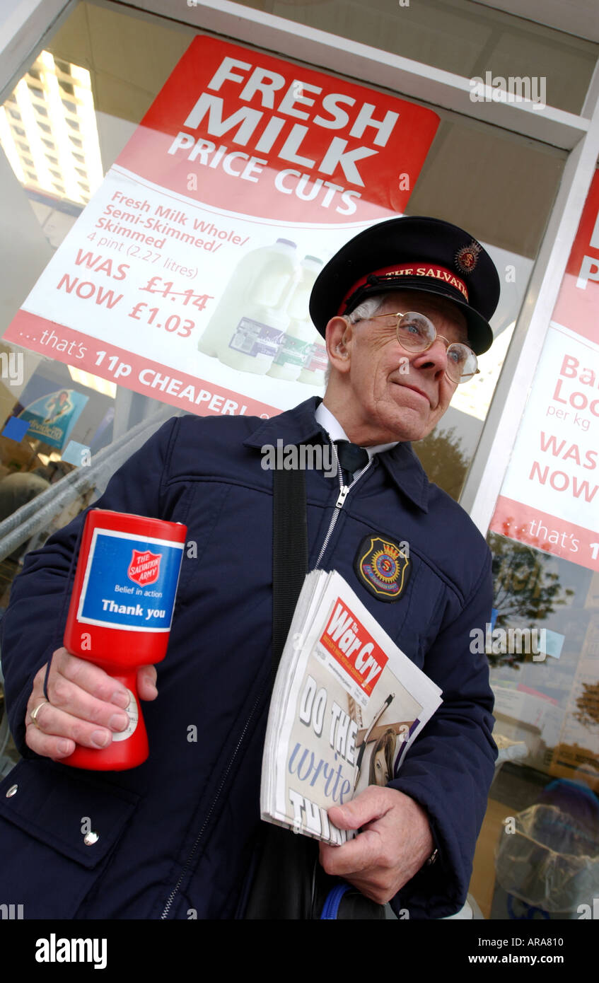 Un esercito della salvezza Officer vendita di grido di guerra giornale al di fuori di un supermercato in Inghilterra, Regno Unito Foto Stock