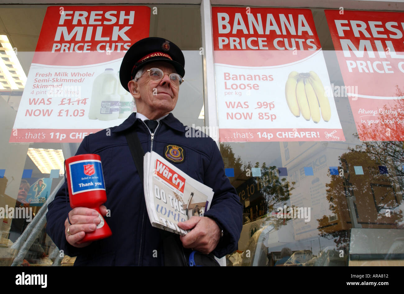 Un esercito della salvezza Officer vendita di grido di guerra giornale al di fuori di un supermercato in Inghilterra, Regno Unito Foto Stock