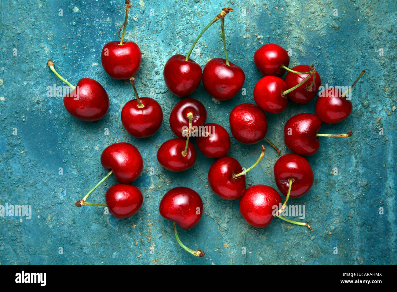 Ciliege rosse su un rustico sfondo blu. Foto Stock