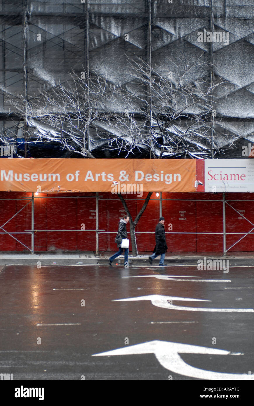 Pedoni attraversare l'Ottava Avenue a Columbus Circle in raffiche di neve nei pressi del futuro Museo delle Arti e Design a New York Foto Stock