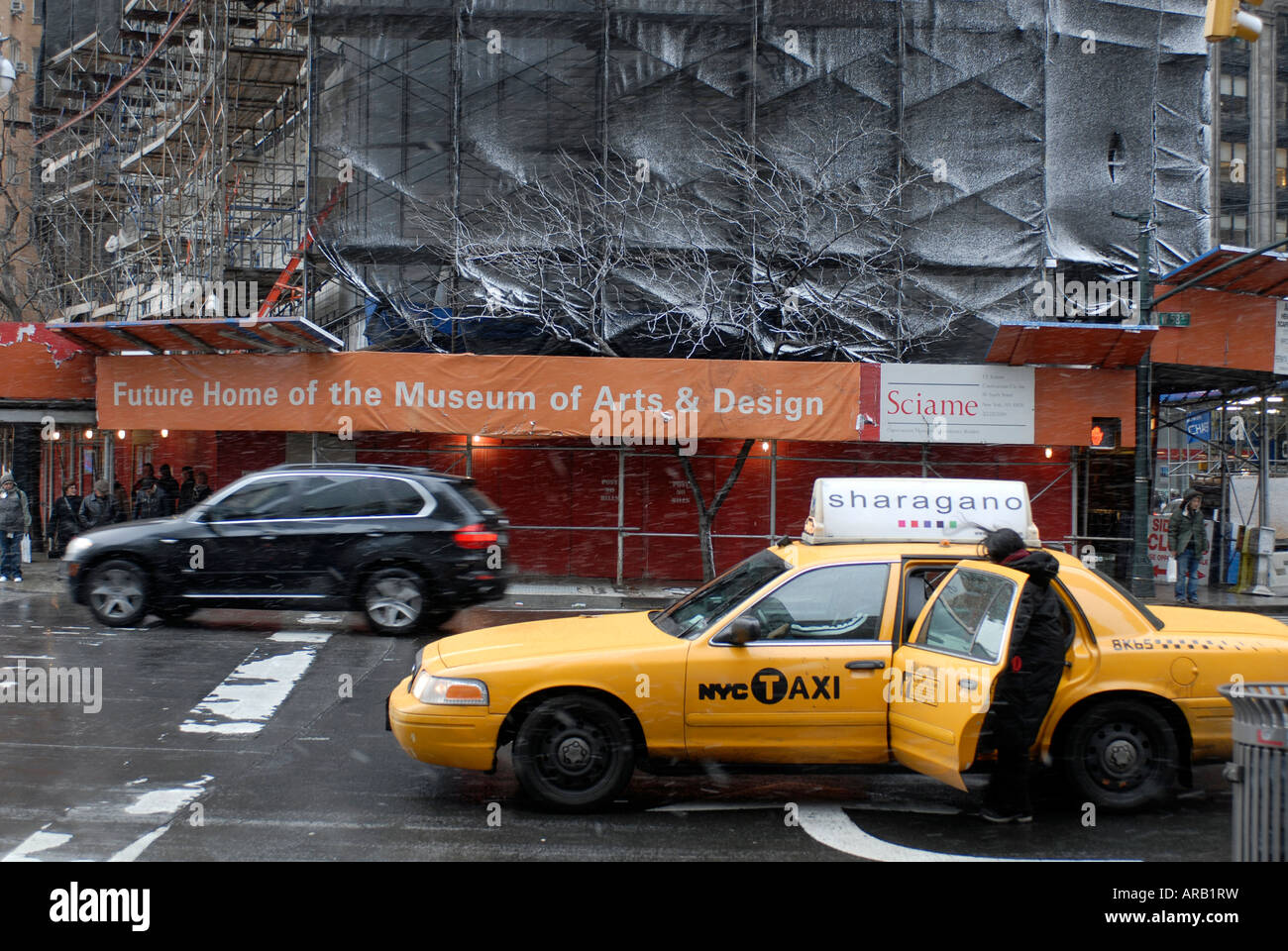 I viaggiatori immettere una cabina sulla Eighth Avenue a Columbus Circle in raffiche di neve nei pressi del futuro Museo delle Arti e Design a New York Foto Stock