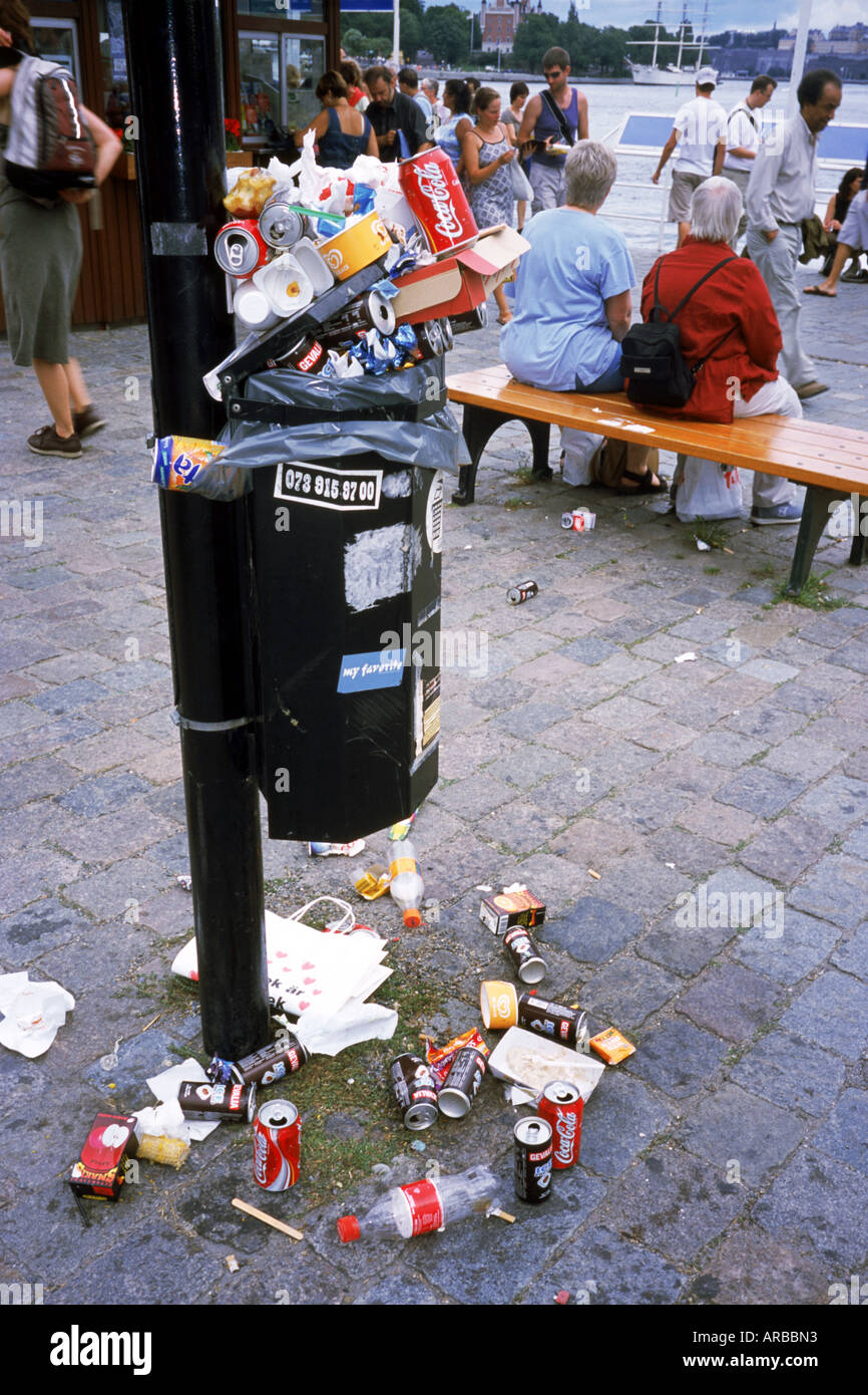 Pubblico nel cestino sovraccarico su una strada di città Foto Stock
