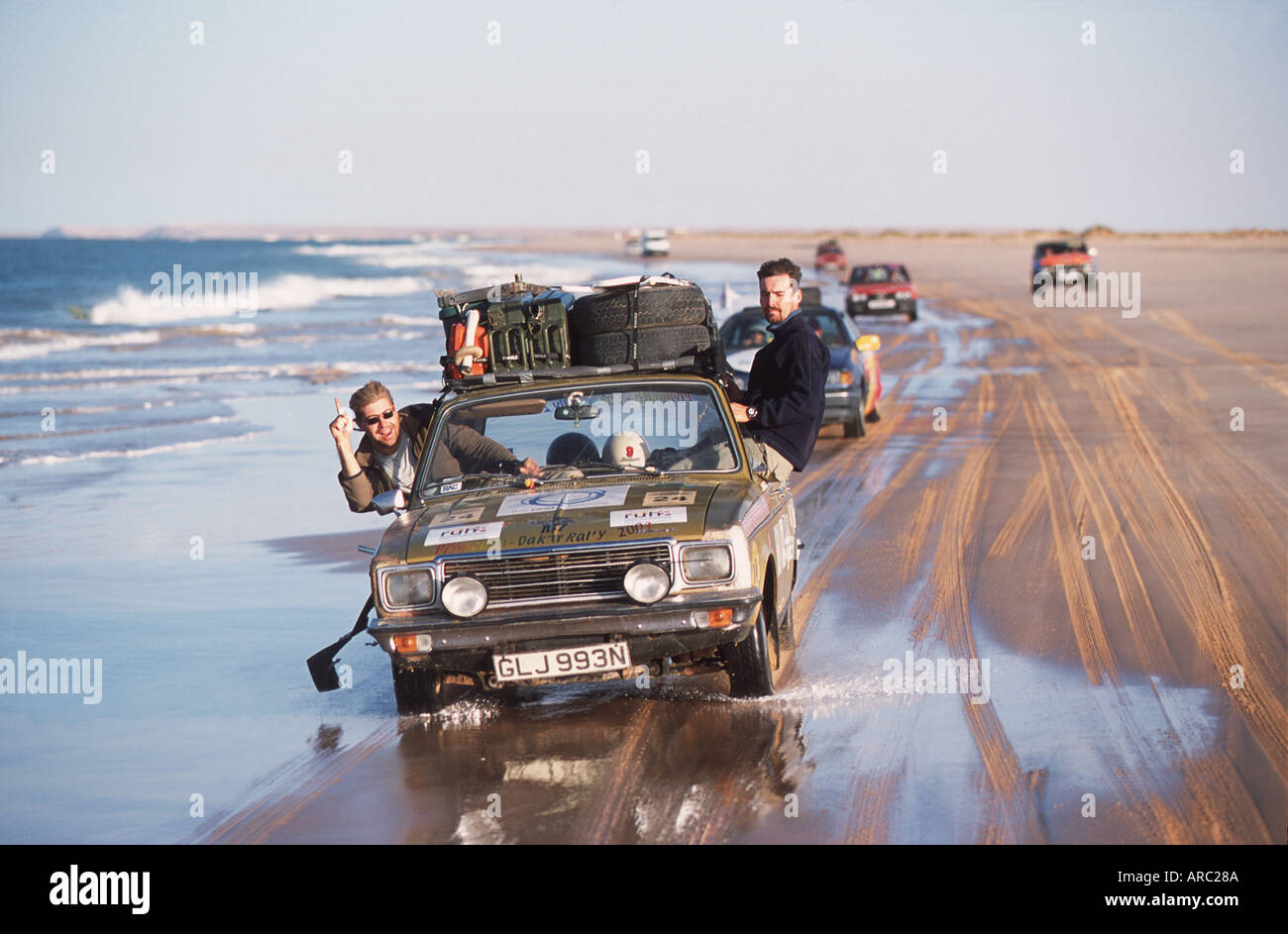 Plymouth Dakar Rally Cars Race lungo il lato della spiaggia in Mauritania Foto Stock