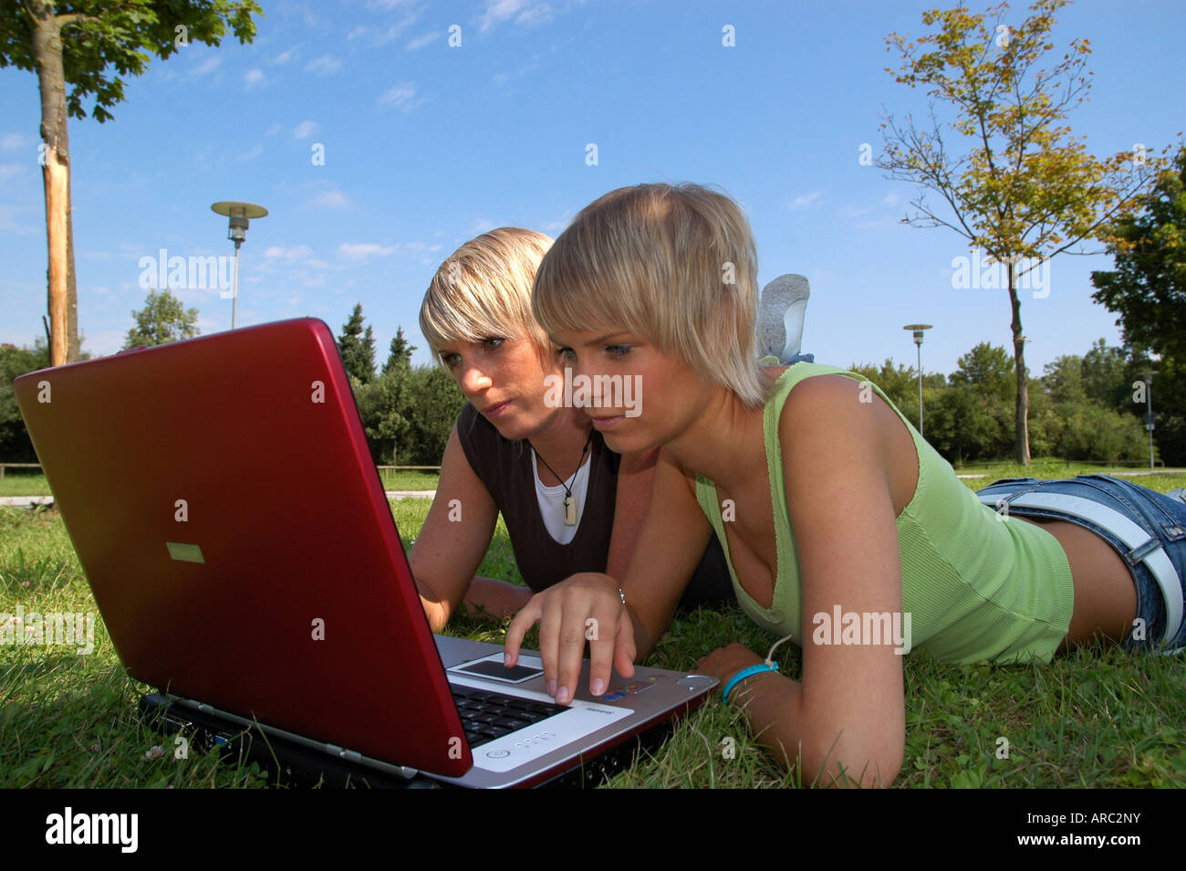 Junge Mädchen mit laptop auf wiese - giovani ragazze giacente in erba lavora con i notebook Foto Stock