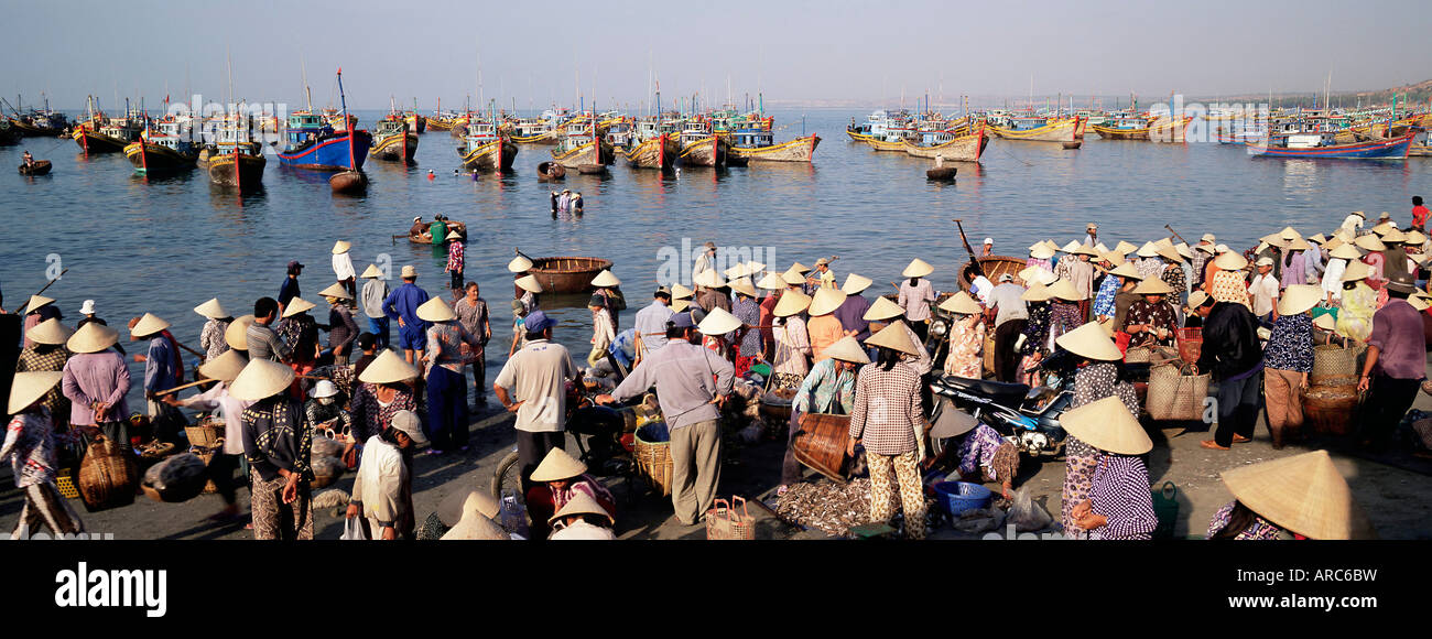 Persone da villaggio di pescatori a raccogliere le catture di mattina da barca da pesca flotta, Mui ne, il centro-sud della costa, Vietnam Foto Stock