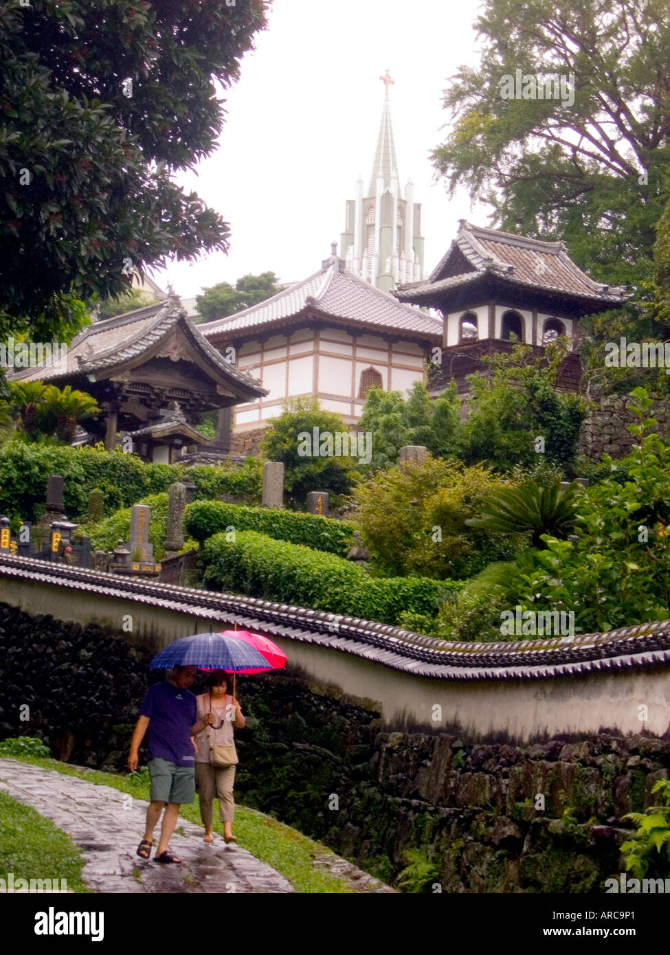 Giappone isola hirado giovane passeggiando per le lane a pioggia con san Francesco Saverio la Chiesa commemorativa in background Foto Stock