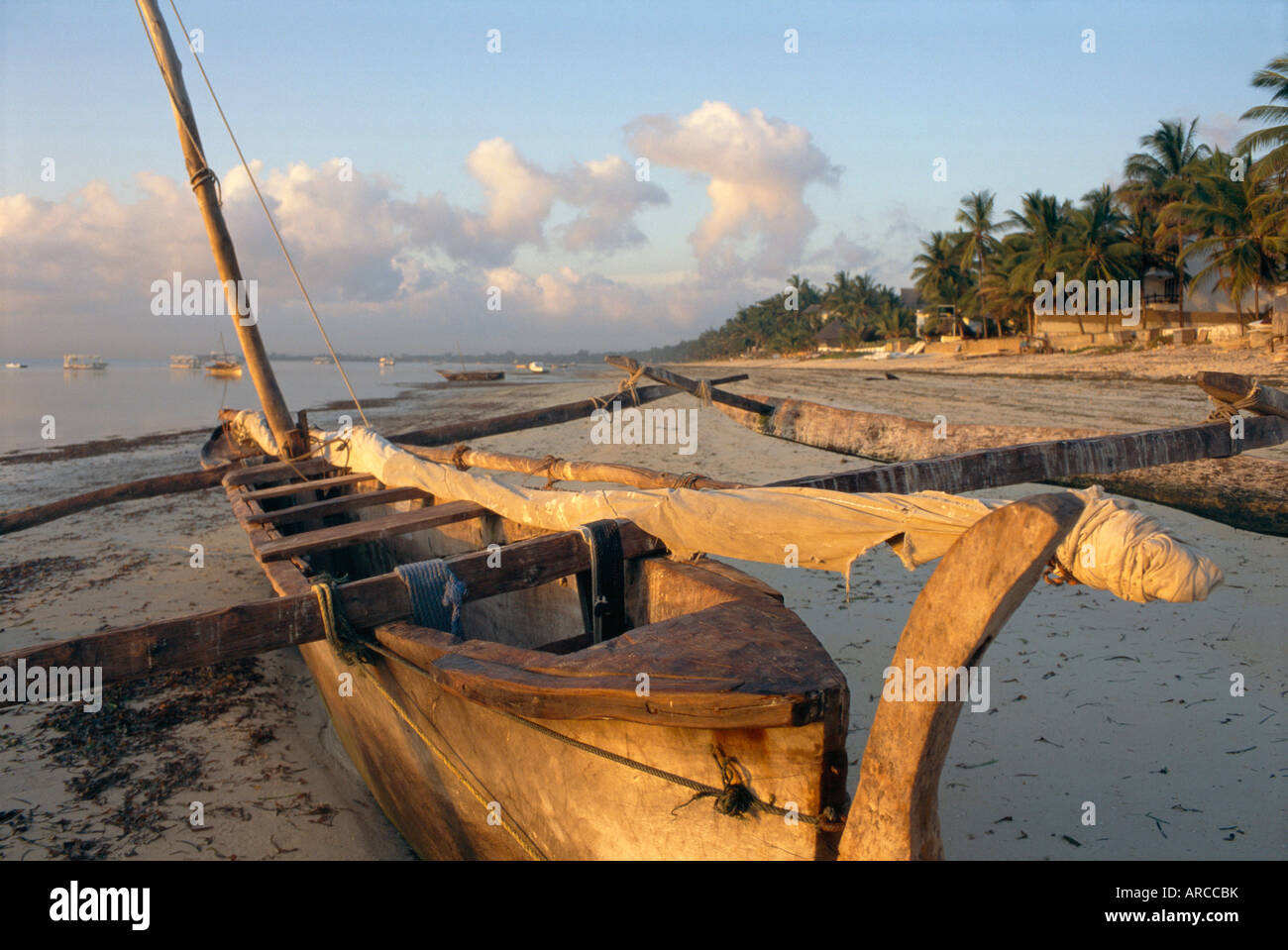 Canoa tirata sulla spiaggia al tramonto, Bamburi Beach, vicino a Mombasa, in Kenya, Africa Foto Stock