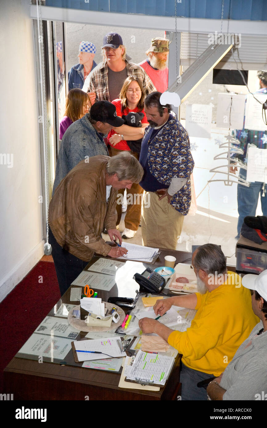 La gente del posto di arrivare ad una libera cena di Natale presso la reception di un ricovero per senzatetto in Barstow CA Foto Stock