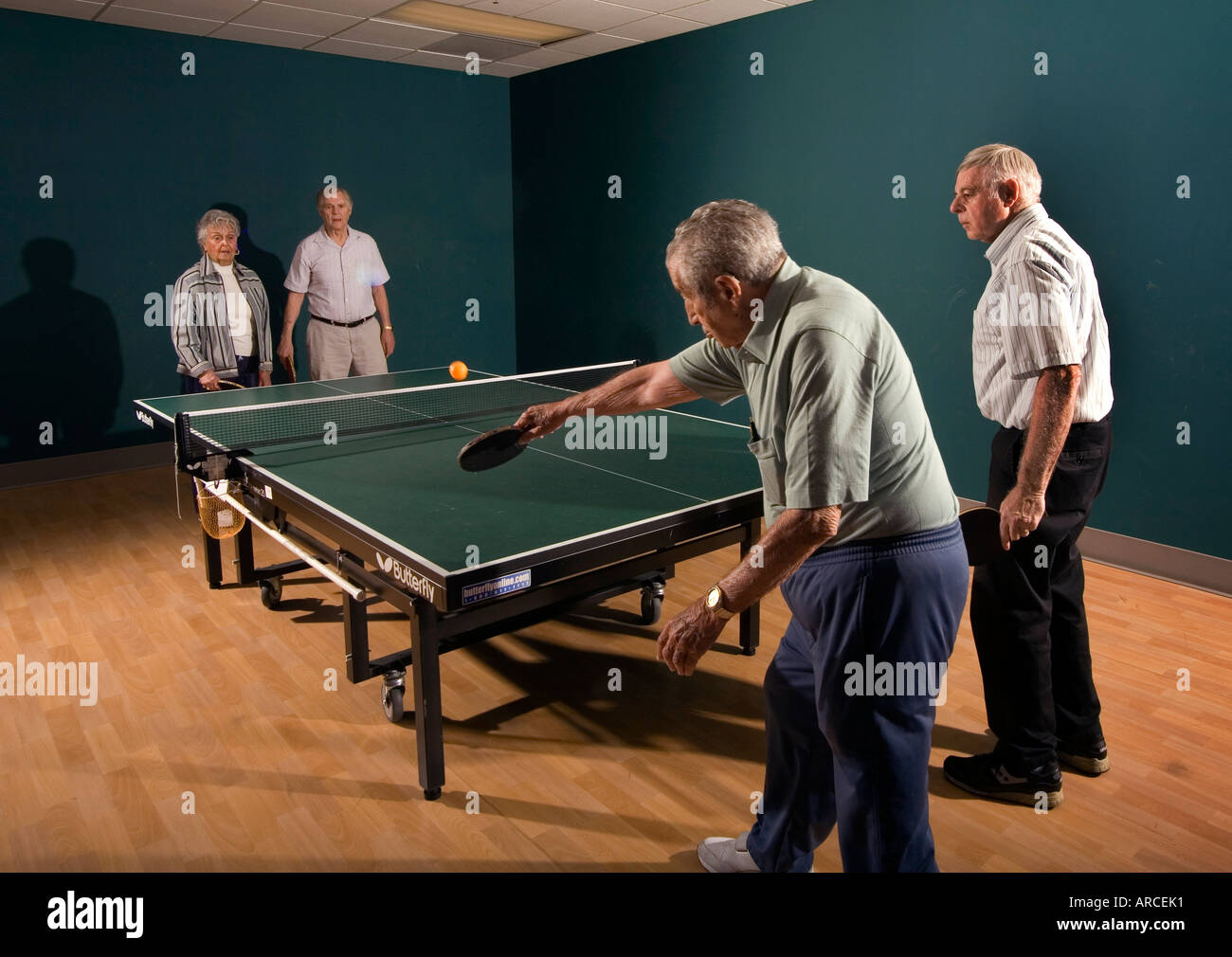 Senior uomini e donne di età compresa tra i 70 s al loro 90 s giocare a ping pong Foto Stock