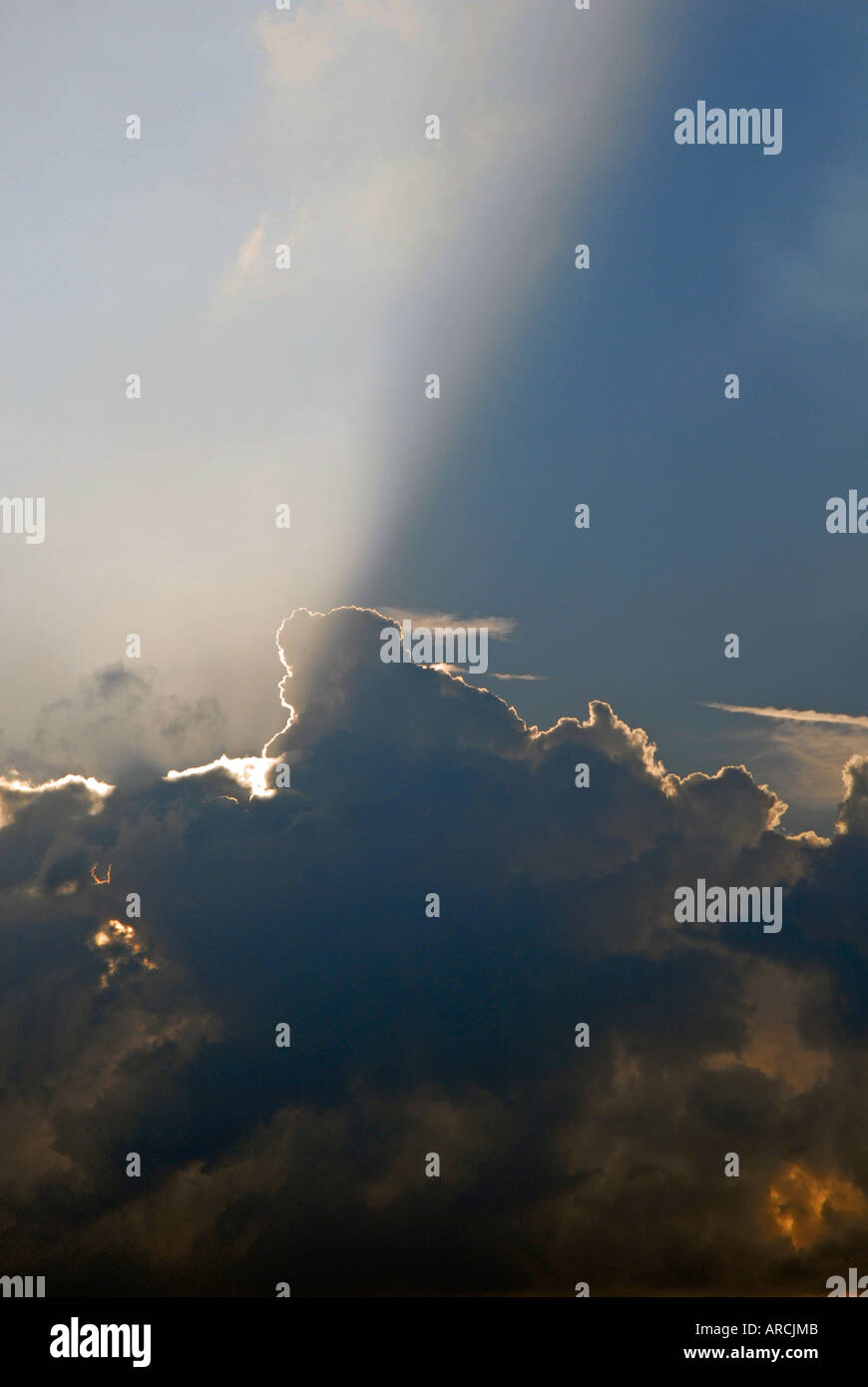 Serata sole che splende da dietro il banco di nuvole e raggi sporgenti oltre il cielo Foto Stock