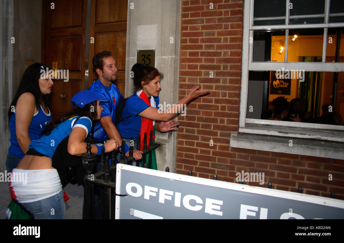 I fans italiani guardando la sanzione di sparare fuori della finestra di ufficio vs Francia durante il 2006 finale di Coppa del Mondo, Soho, Londra Foto Stock