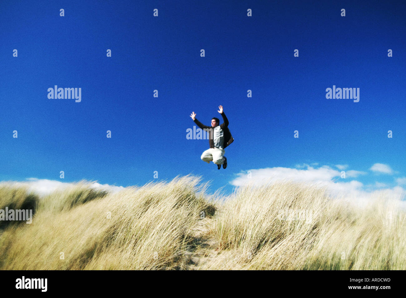 L'uomo saltando oltre le dune di sabbia Foto Stock