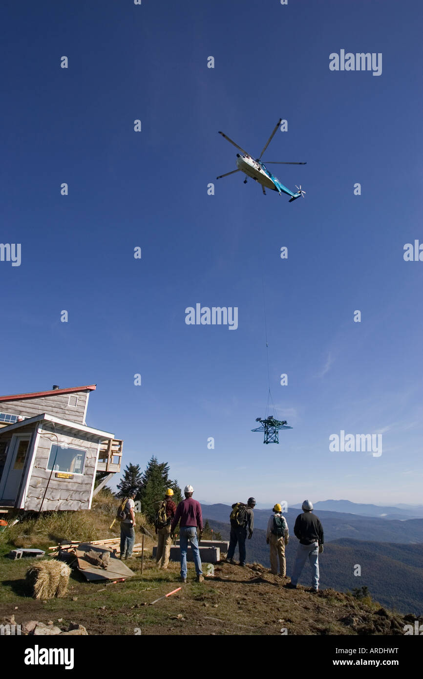 Un elicottero solleva una nuova sedia singola torre in luogo a Mad River Ski Area in Fayston, Vermont. Foto Stock