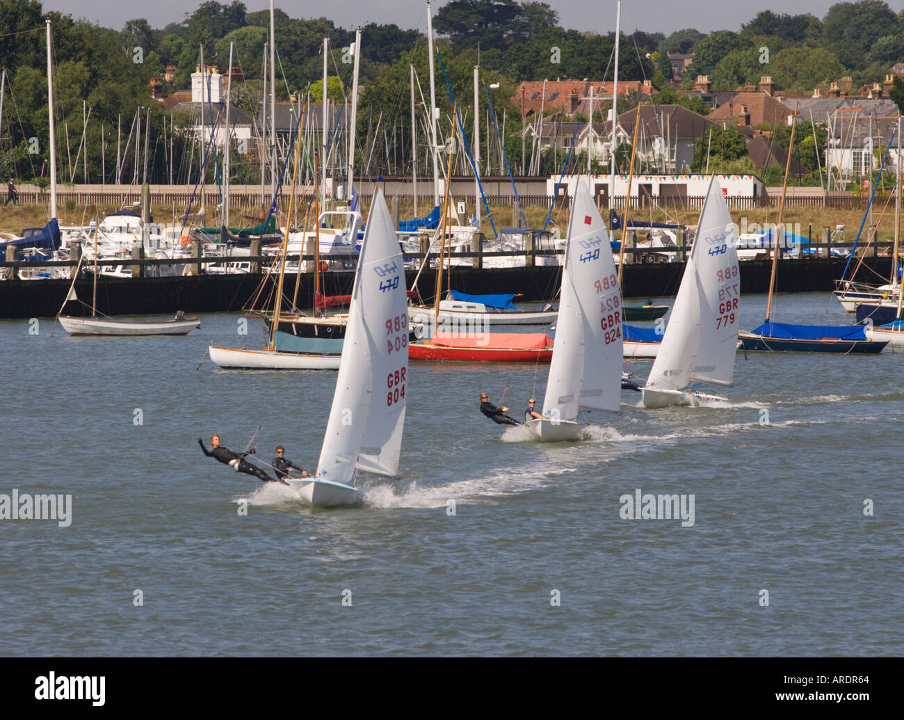Trio di classe olimpica 470 due uomo racing derive a pieno la vela in linea con centinaia di yacht a montanti al di là di Lymington Inghilterra Foto Stock