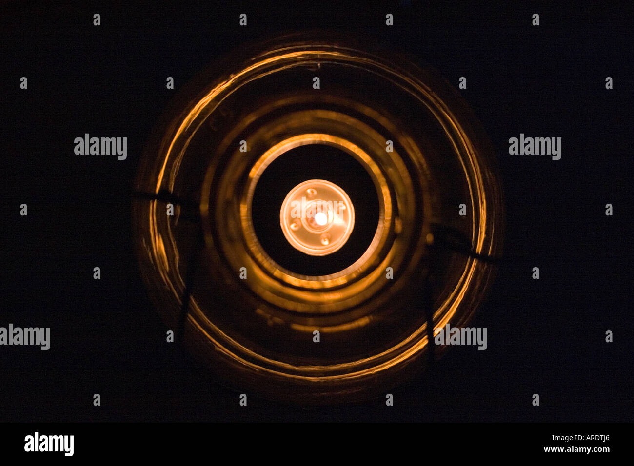 Luce di tè candela in a collo di bottiglia di vetro affumicato titolare visto dal di sopra Foto Stock