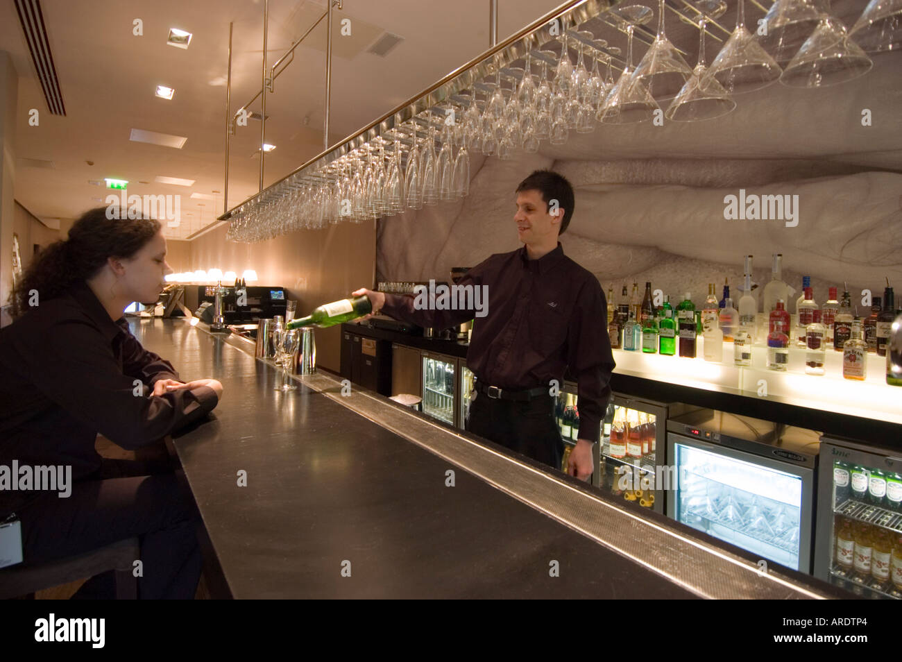 Barman versa da bere in un hotel contemporaneo bar Foto Stock