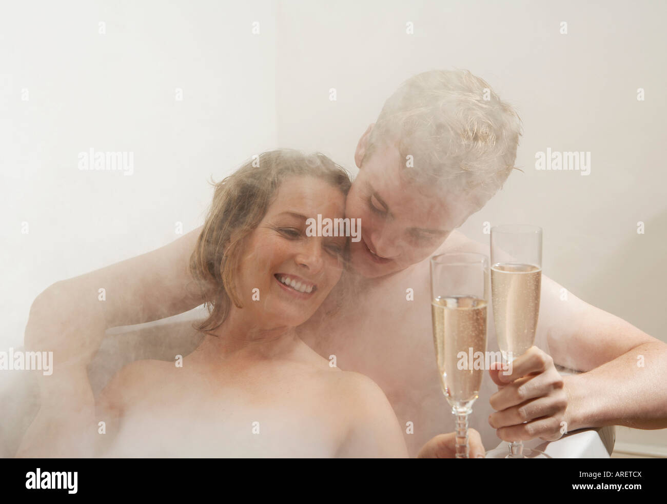 L uomo e la donna di bere nella vasca da bagno Foto Stock