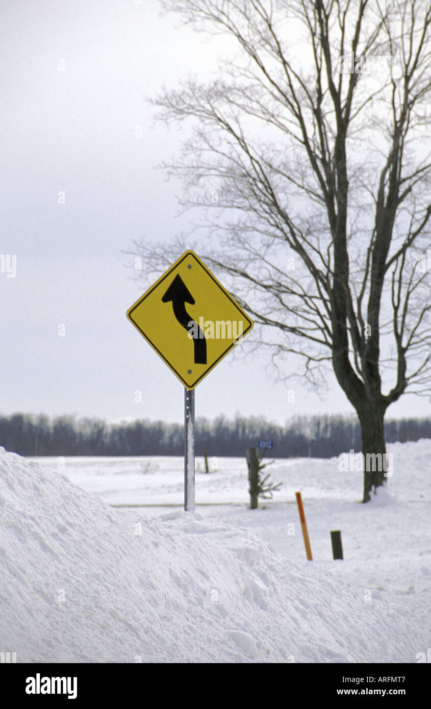 Winding Road Sign sepolto nel cumulo di neve Foto Stock