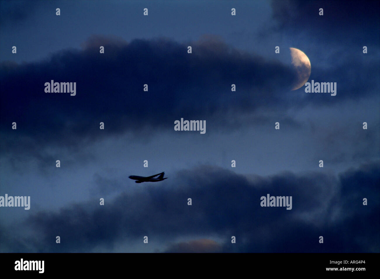 Volo aereo passeggeri e un quarto di luna in un cielo di sera Foto Stock