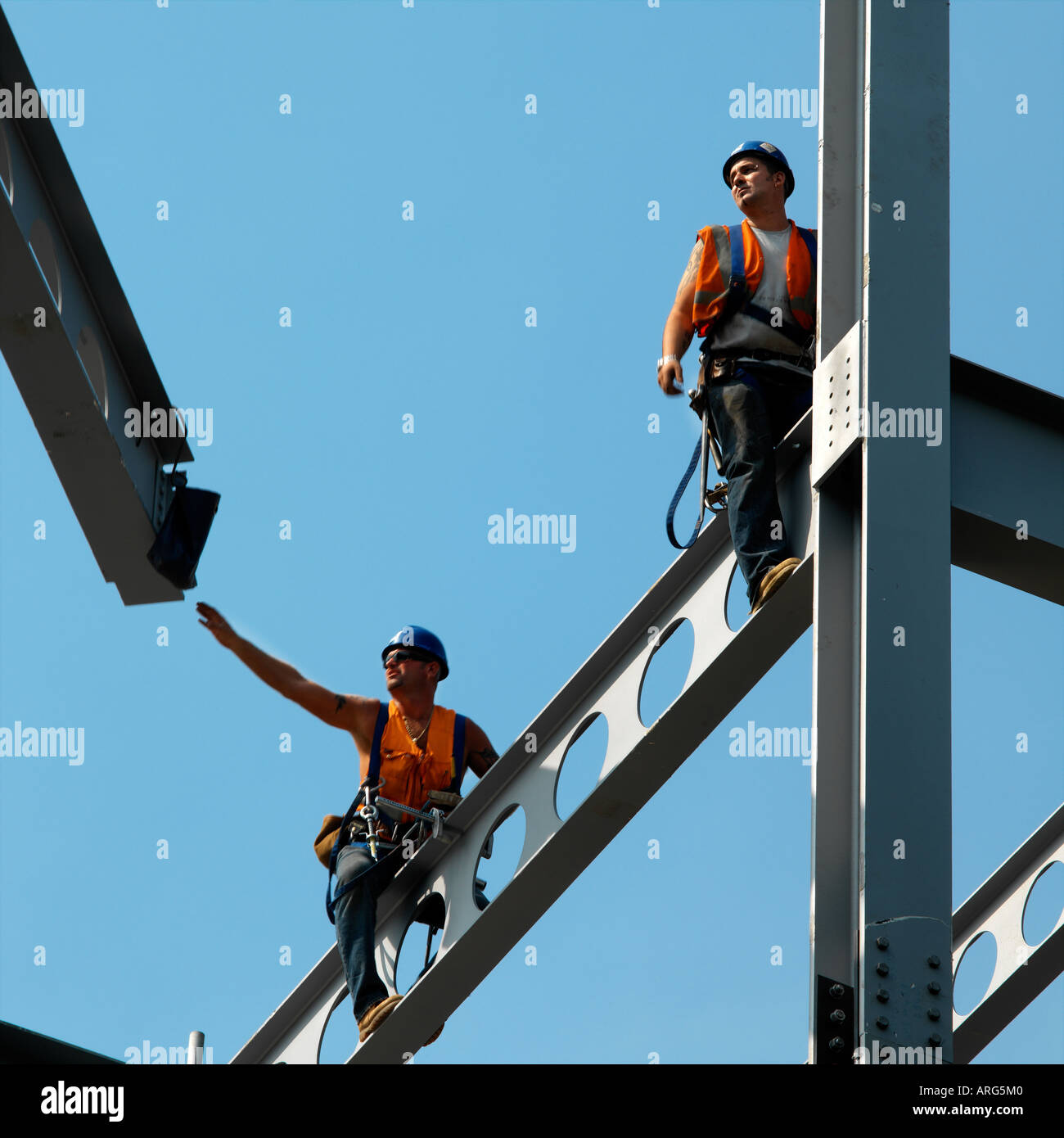 Steeplejacks lavorando sul sito di costruzione contro vivid blue sky Foto Stock