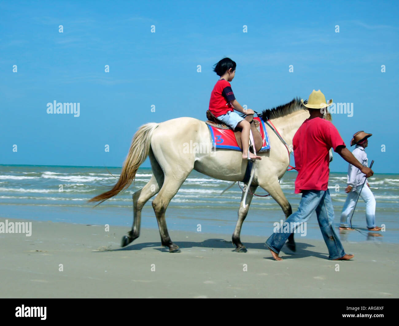 "Viaggio Isole Thai' figlio Equitazione su 'Cha Am " spiaggia esotica Thailandia sabbia 'tropical island beach' Foto Stock