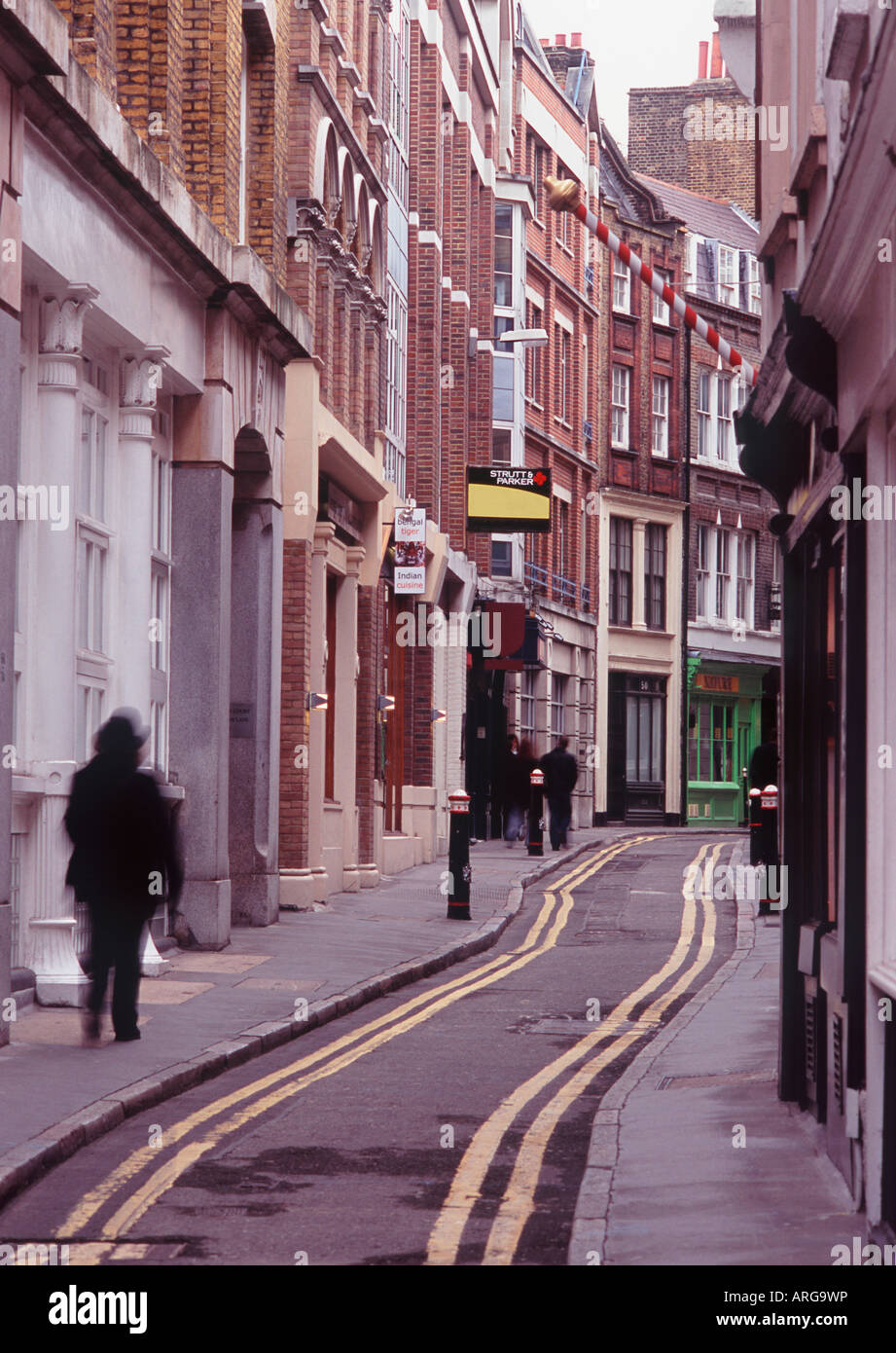 Doppio giallo linee passanti attraverso strette e tortuose strade medievali di Blackfriars con persona in movimento sfocate, City of London Foto Stock