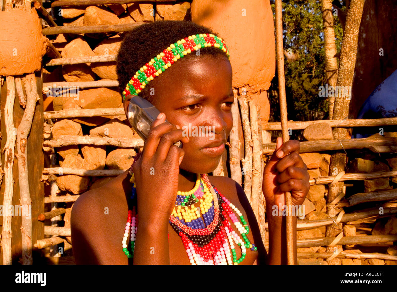 Bambino colorato con un telefono cellulare in nativo tribù Zulu Shakaland al centro-Sud Africa Foto Stock
