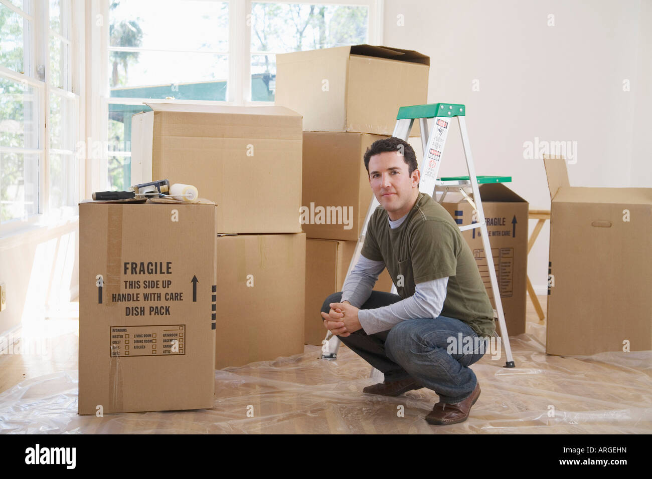 Uomo in casa con scatole di cartone Foto Stock