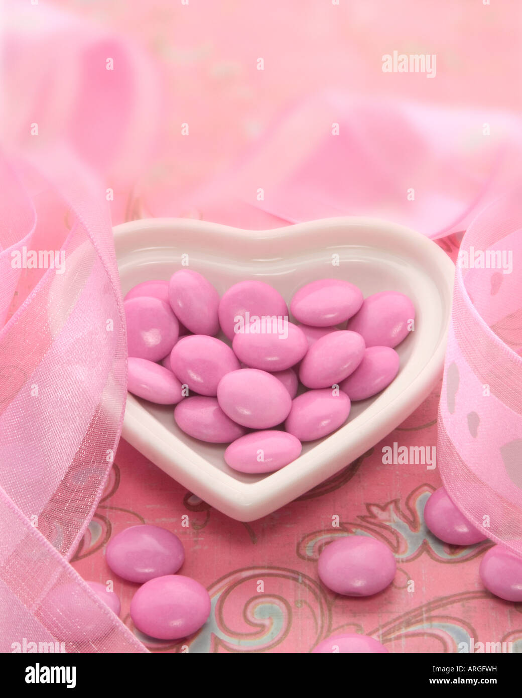 Caramelle rosa nel piatto Heart-Shaped Foto Stock