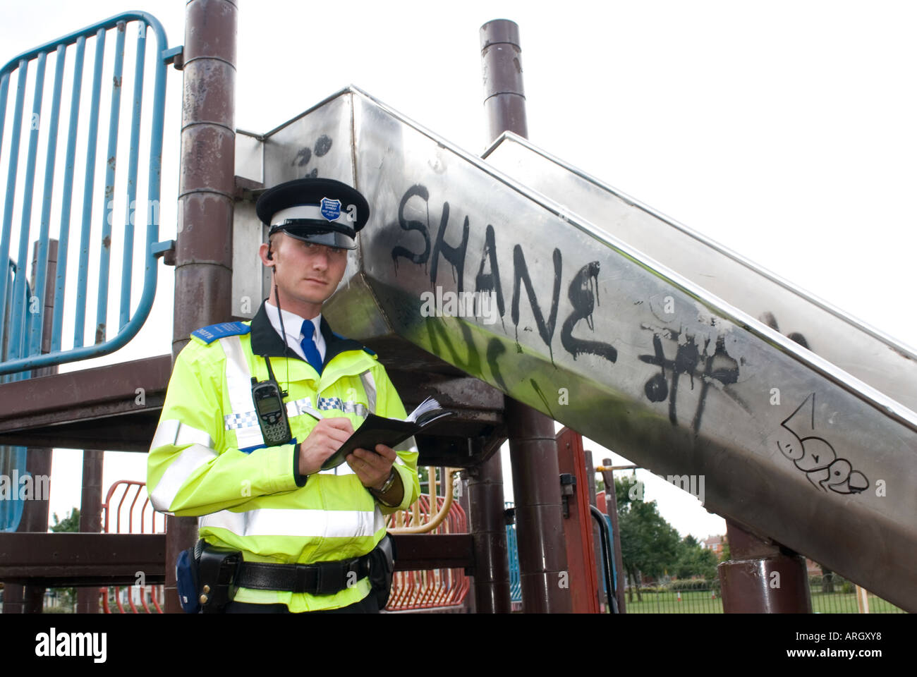 Una comunità di polizia support officer PCSO sul dovere di Coventry, notando graffiti e vandalismo Regno Unito Foto Stock