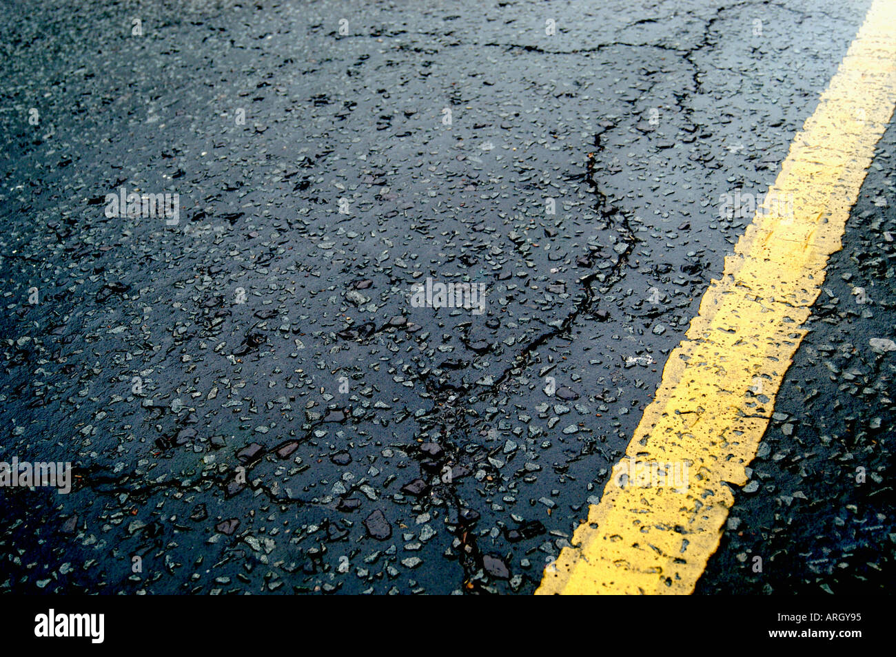 Linea gialla singola su incrinato su strada asfaltata. Inghilterra, Regno Unito Foto Stock