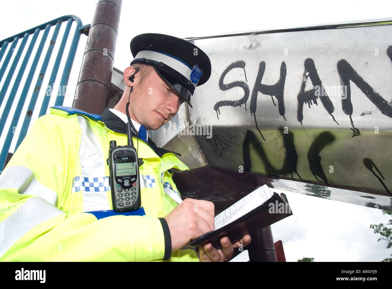 Una comunità di polizia support officer PCSO sul dovere di Coventry, Regno Unito rilevando graffiti Foto Stock