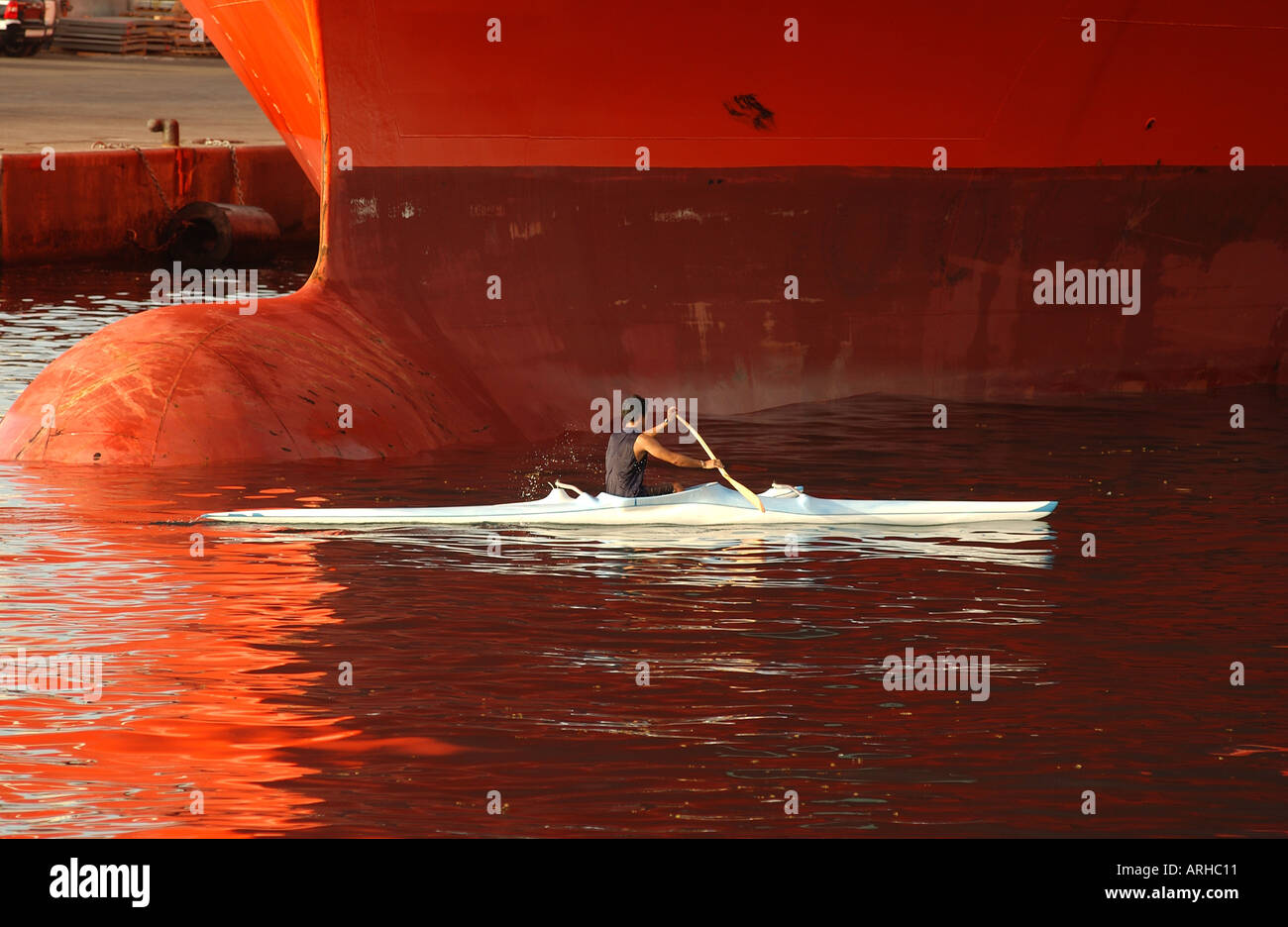 Un uomo che rema con una canoa in prossimità di una grande nave di Tahiti Papeete Polinesia Francese del Sud Pacifico Foto Stock