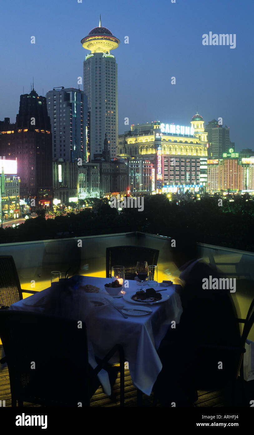 Persone presso la terrazza sul tetto a Kathleen s 5 ristorante con viste sul Parco Renmin Shanghai illuminato di sera Foto Stock
